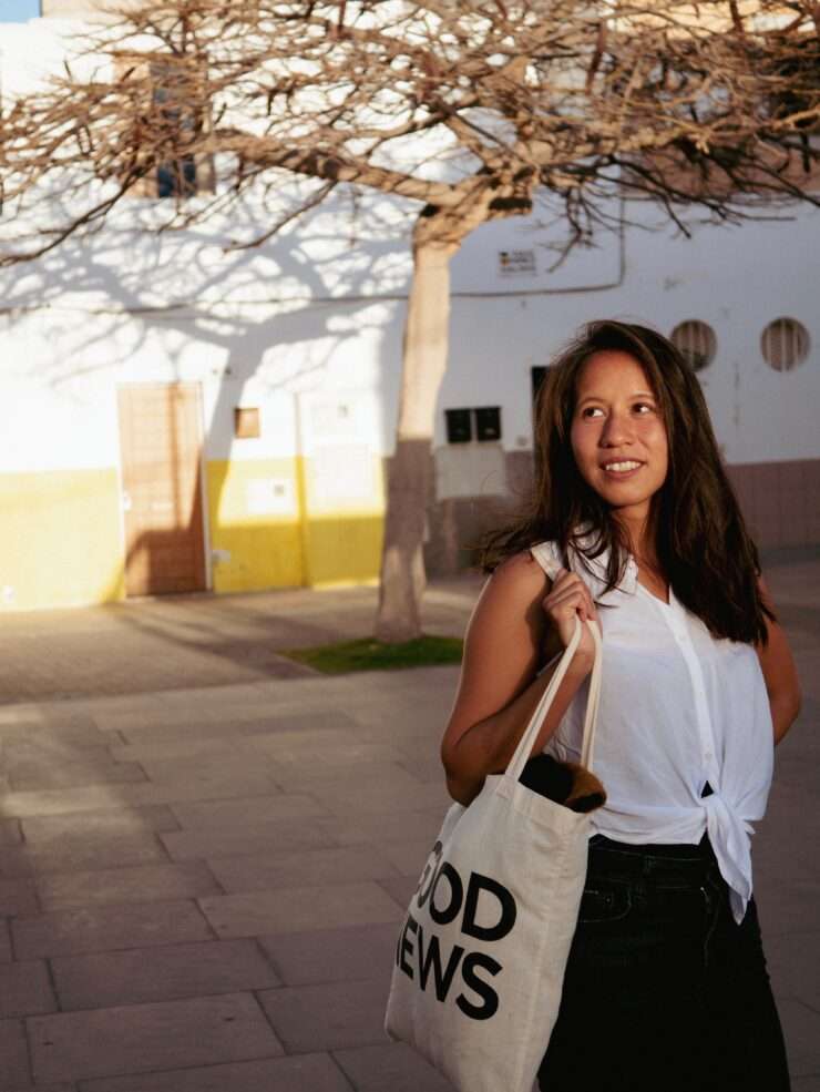 junizeit-Bloggerin Thuy-An steht auf einem Platz im Zentrum von Corralejo, der von der Abendsonne beleuchtet wird.